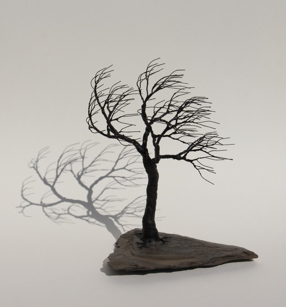 Ein Drahtbaum steht im Wind.